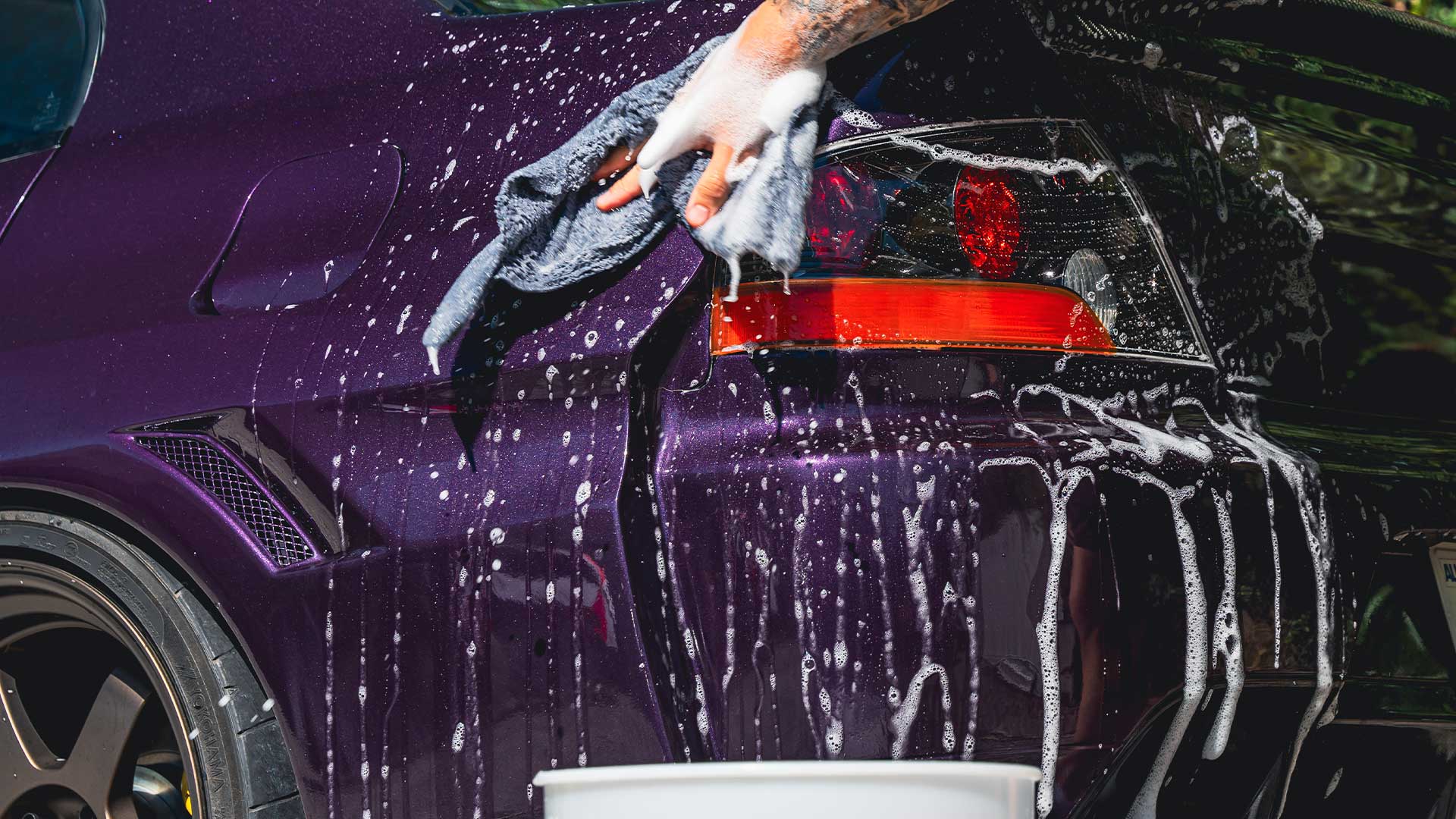 Purple car receiving a foam hand wash