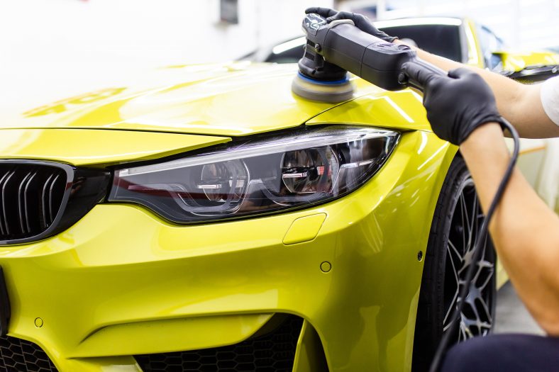 Yellow vehicle being machine polished